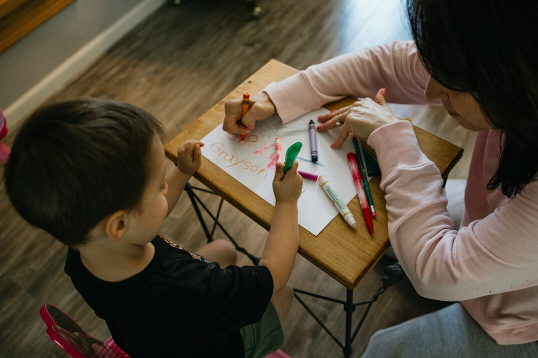 Mentor guiding a colleague through notes at a desk